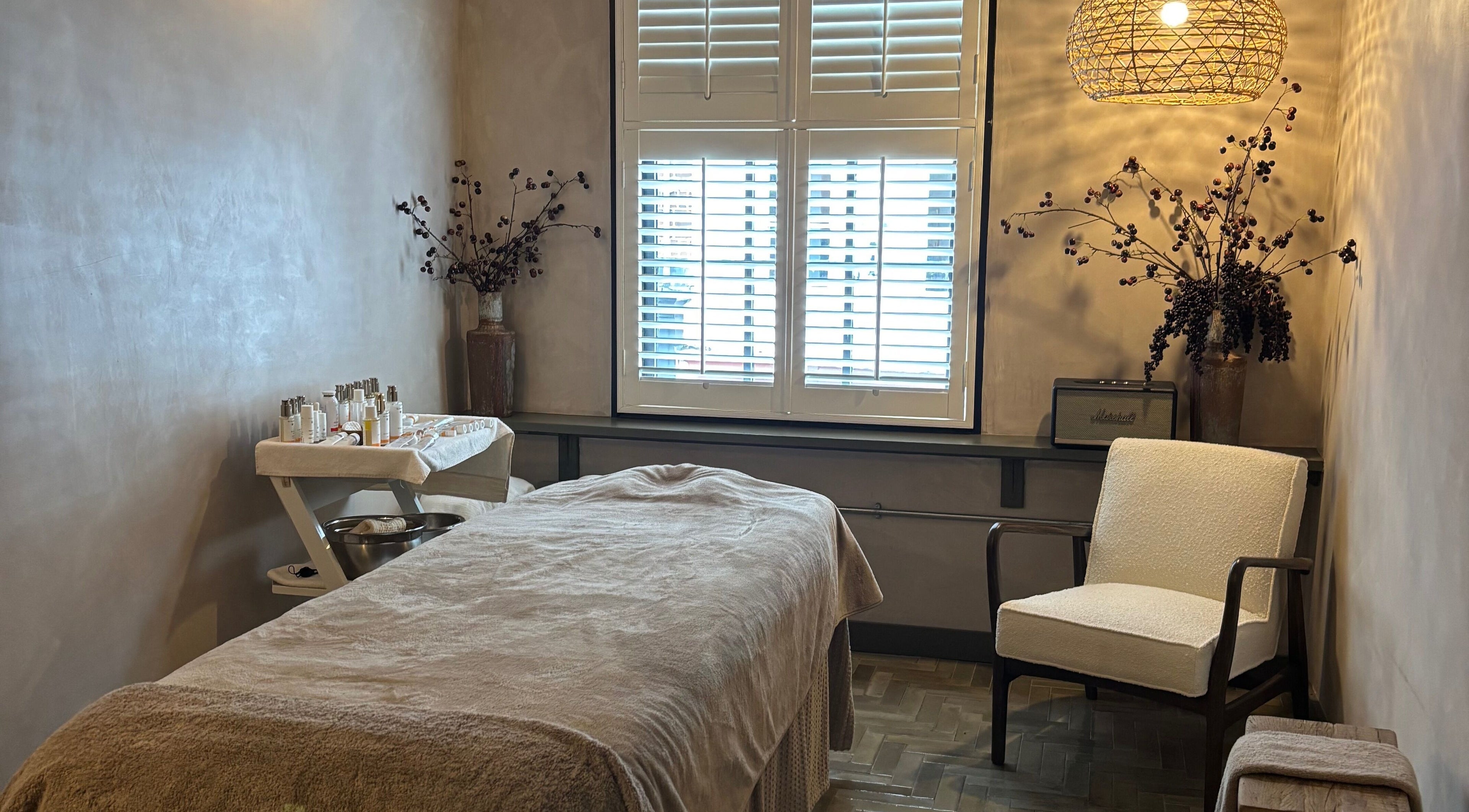 Cozy treatment room at Elaine Sadler Skin Health, Warwick, England, GB, featuring a plush massage table and ambient lighting.
