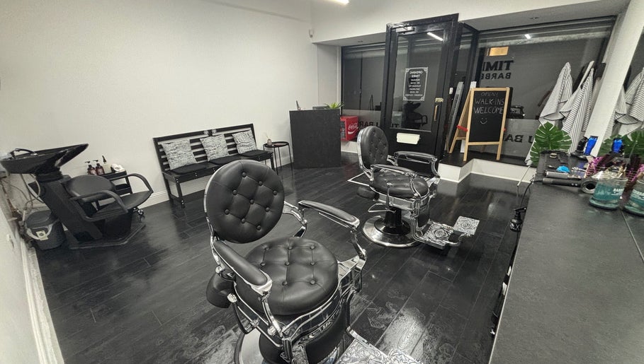 Modern interior of TIMI J BARBERS in Paisley, Scotland, GB, featuring stylish black chairs and sleek decor.