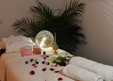 Luxurious massage table setup at Relive Spa ريلايب اسفا, Al Rayyan, Doha Municipality, QA with oils and flowers.