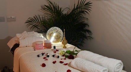 Luxurious massage table setup at Relive Spa ريلايب اسفا, Al Rayyan, Doha Municipality, QA with oils and flowers.