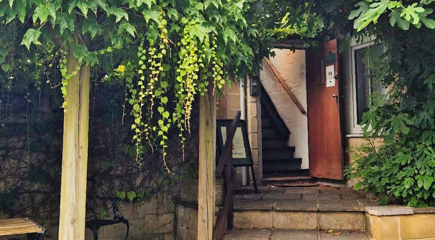 Charming entrance of Zizzi Zemro Functional Massage, surrounded by greenery in Bradford-on-Avon, England, GB.