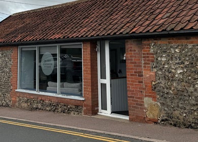 Exterior of The Next Generation Hair Salon in Diss, England, GB with rustic brick and flint walls.
