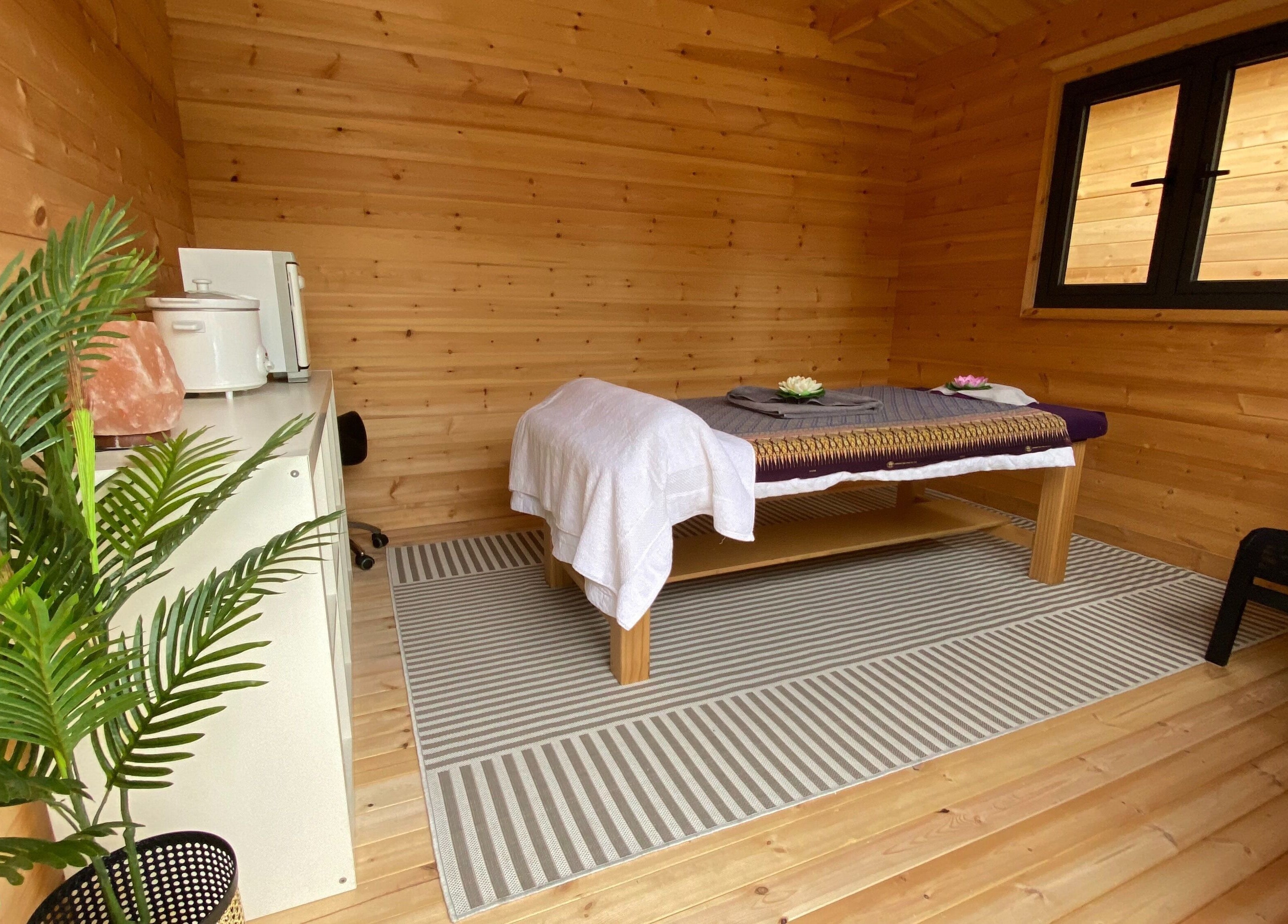 Warm wooden massage room at Massage Loft (Drury), Auckland, NZ, with table and calming decor.