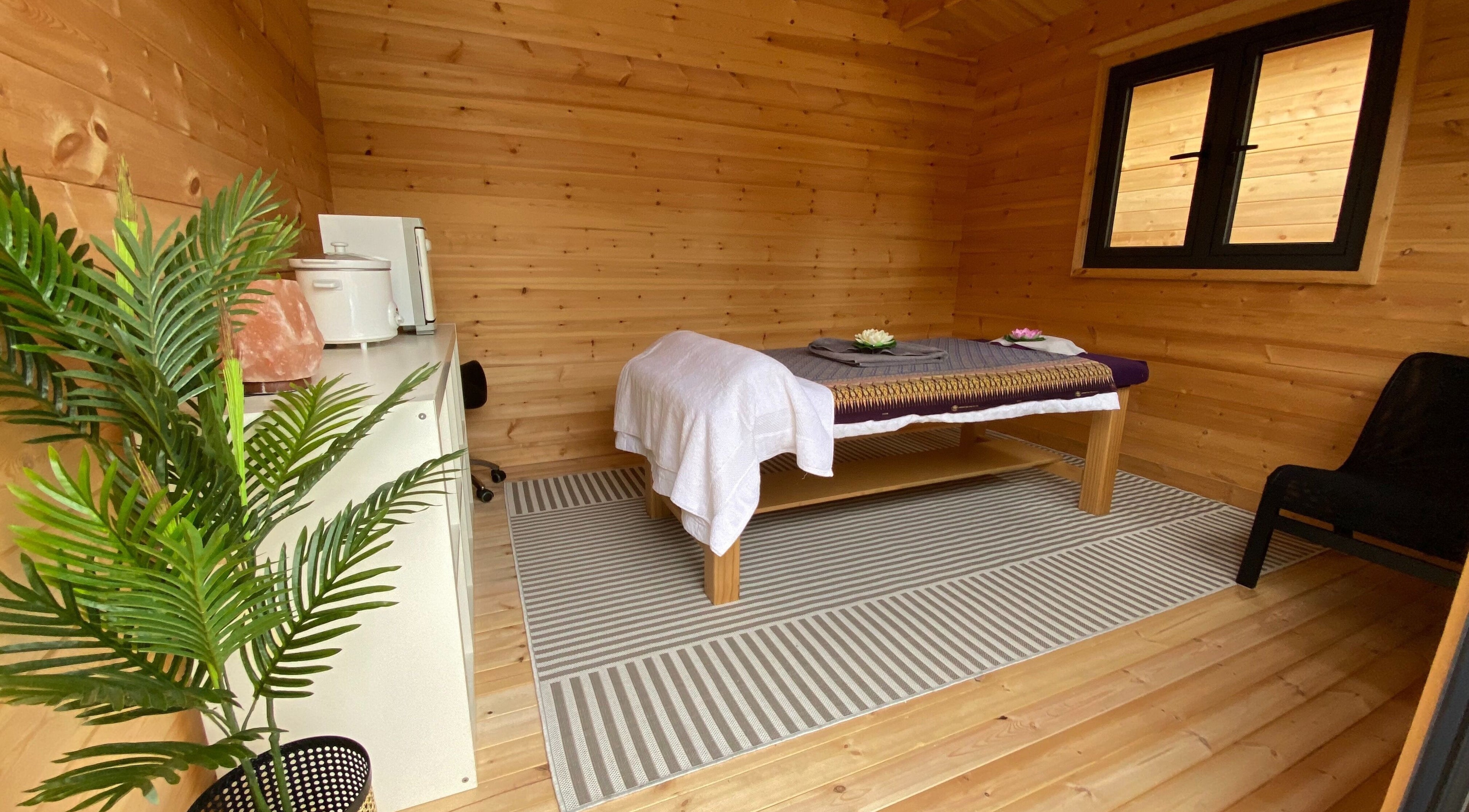 Warm wooden massage room at Massage Loft (Drury), Auckland, NZ, with table and calming decor.