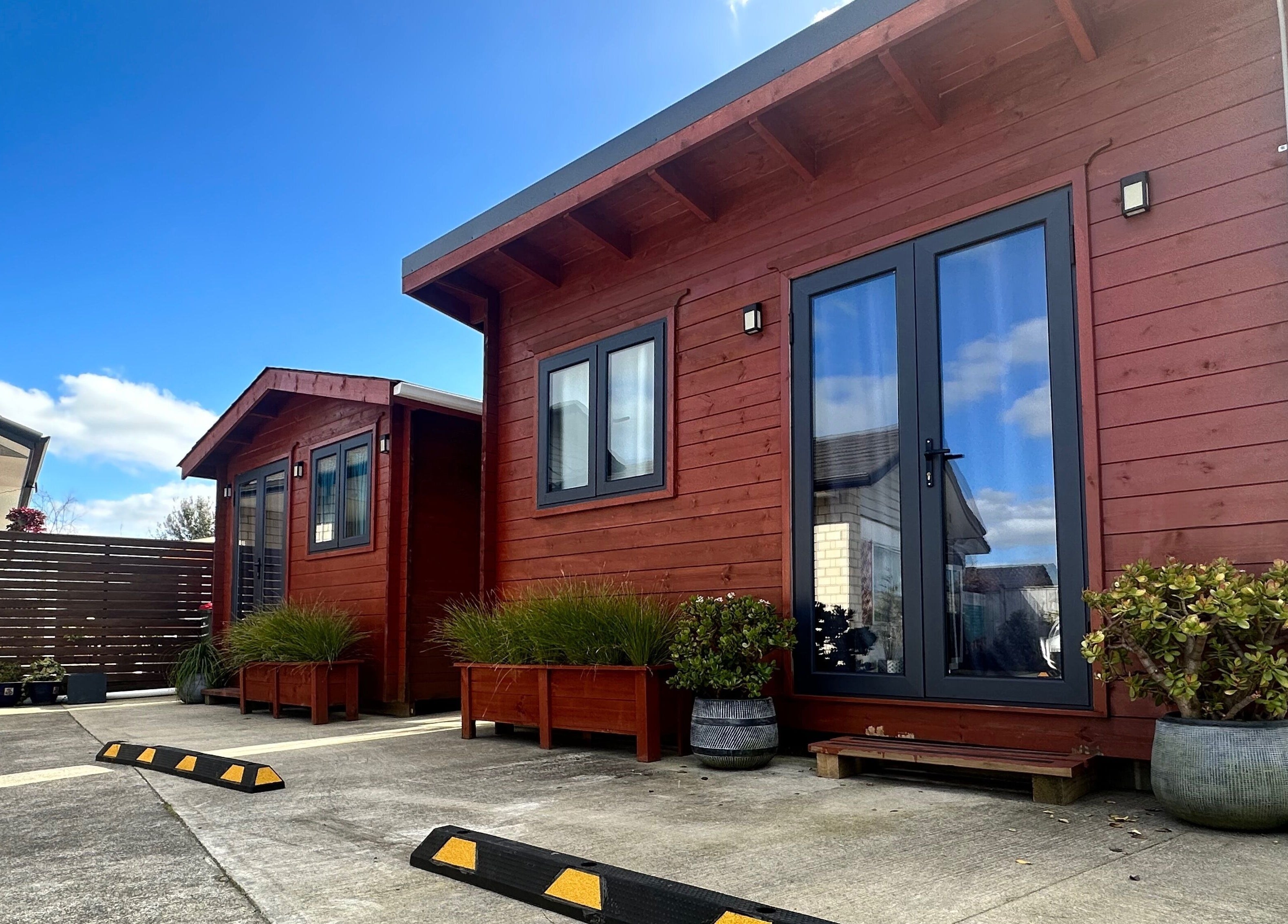 Massage Loft (Drury) exterior in Auckland, NZ with wooden facade and potted plants.