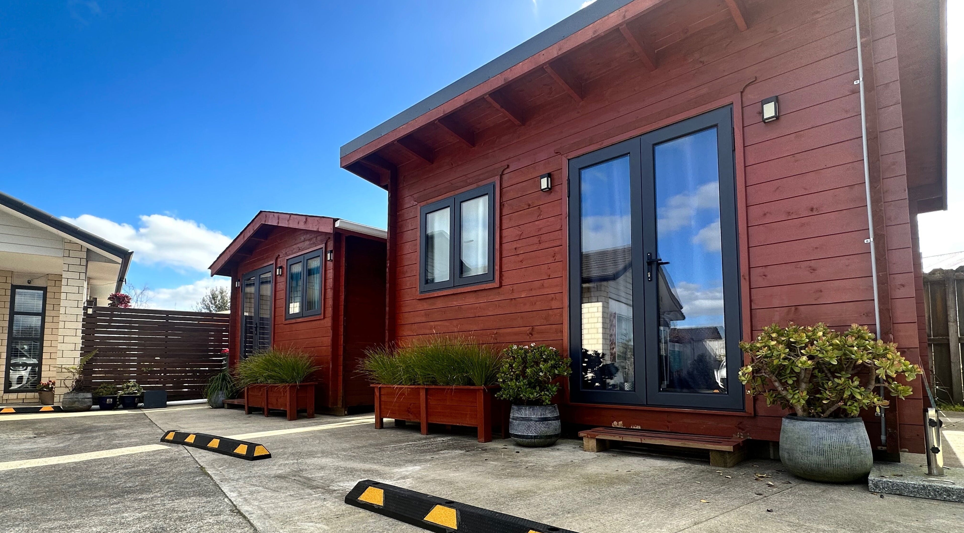 Massage Loft (Drury) exterior in Auckland, NZ with wooden facade and potted plants.
