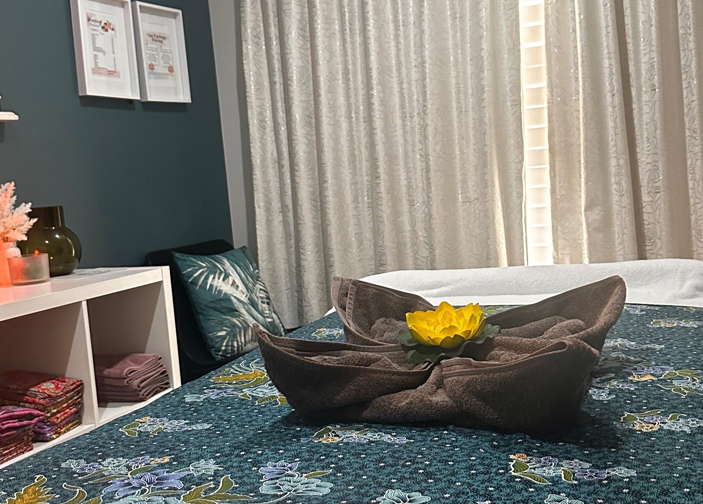 Relaxing massage room at Massage Loft (Drury) in Auckland, NZ with candles and a floral-covered table.