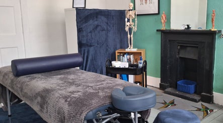 Therapy room at FT Sports Massage Therapy in Wakefield, England, GB, featuring a massage table and anatomical models.