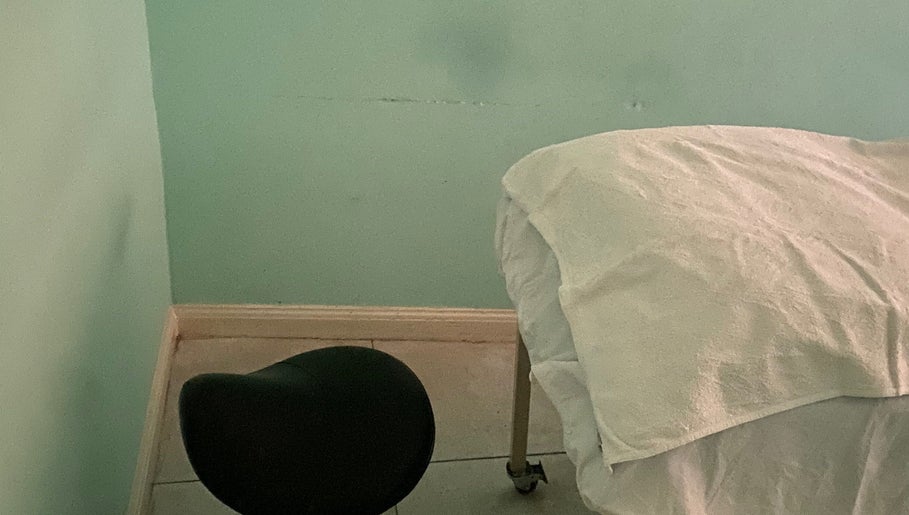 Treatment room at Subrina’s Golden Touch in Kingston, St. Andrew Parish, with a prepared massage table.