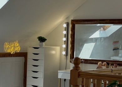 Elegant makeup area at Réalta Studio, County Mayo, IE with mirror, lights, and decor.