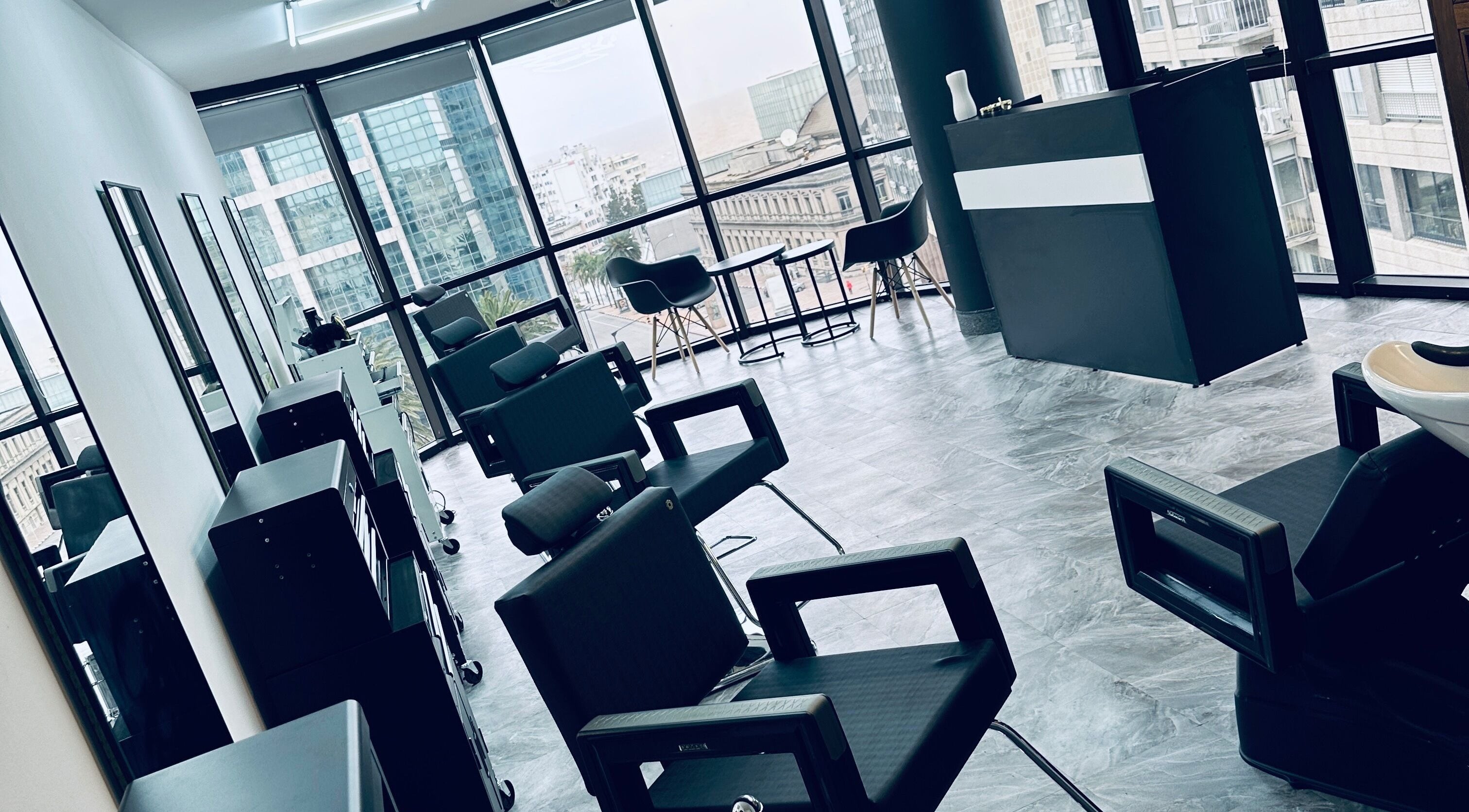 Interior moderno de BLK-21 Studio en Montevideo, Departamento De Montevideo, UY, con sillas de salón y vistas urbanas.