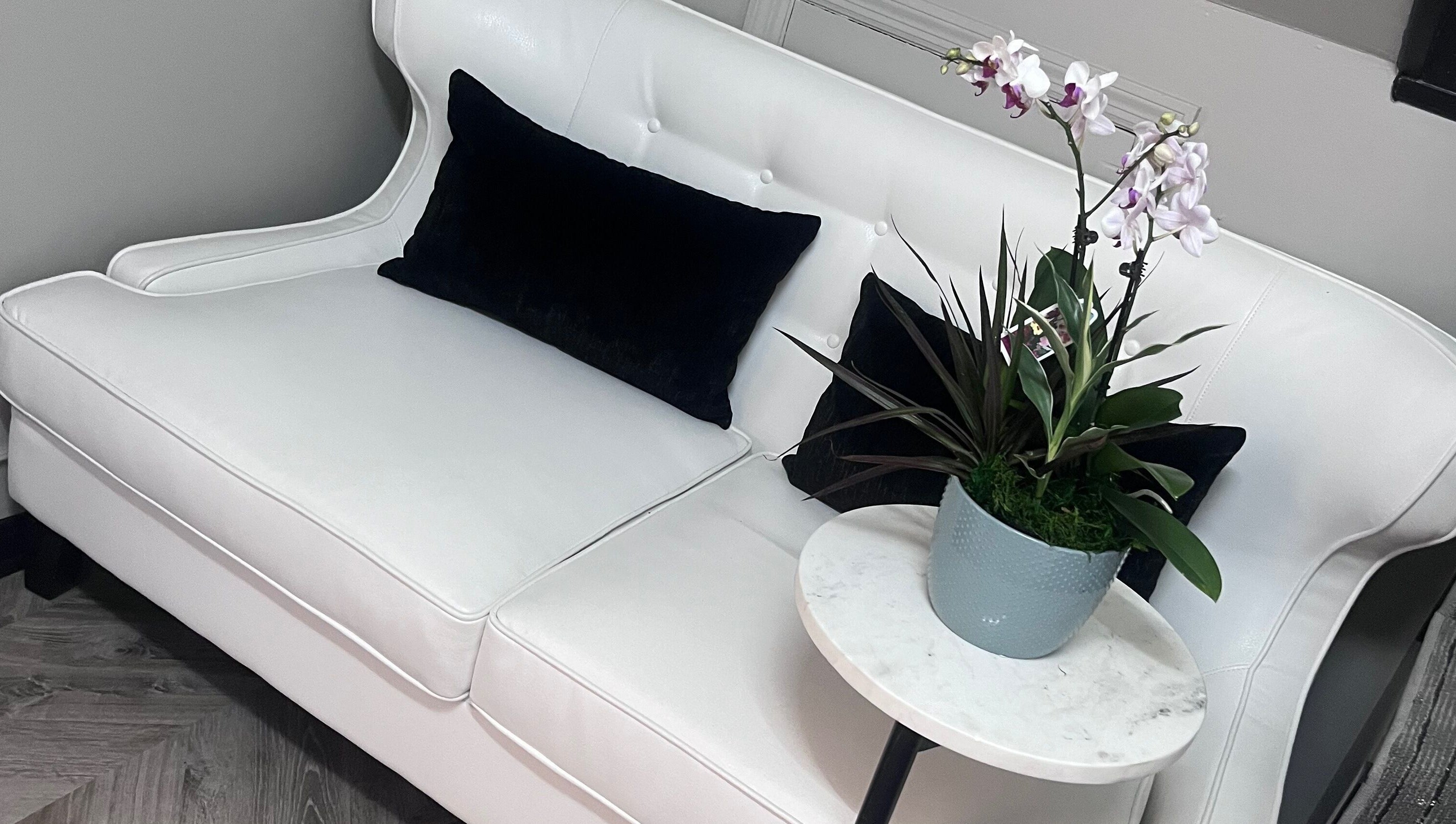 Elegant seating area with white couch at Luxe Aesthetics, Lexington, Kentucky, US.