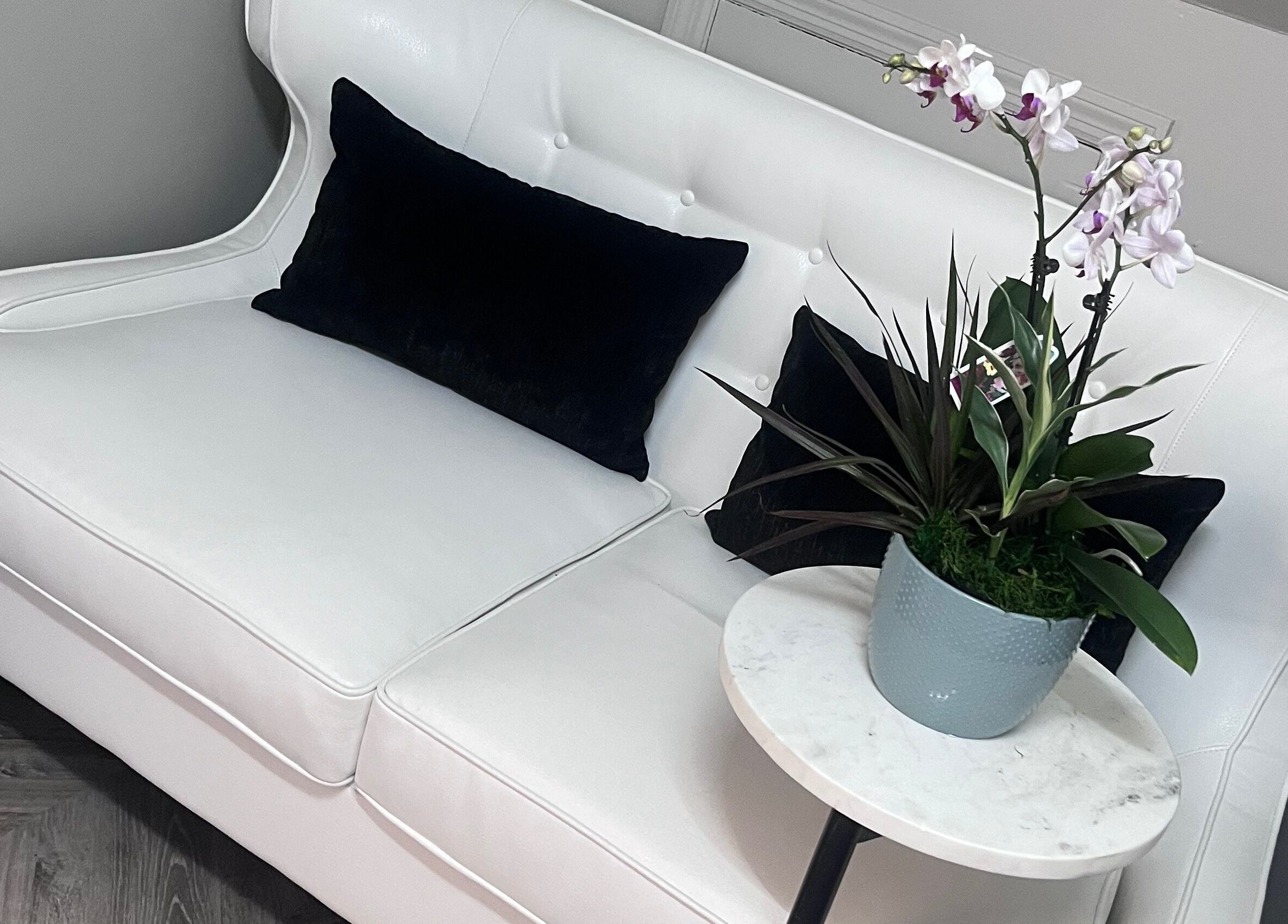 Elegant seating area with white couch at Luxe Aesthetics, Lexington, Kentucky, US.