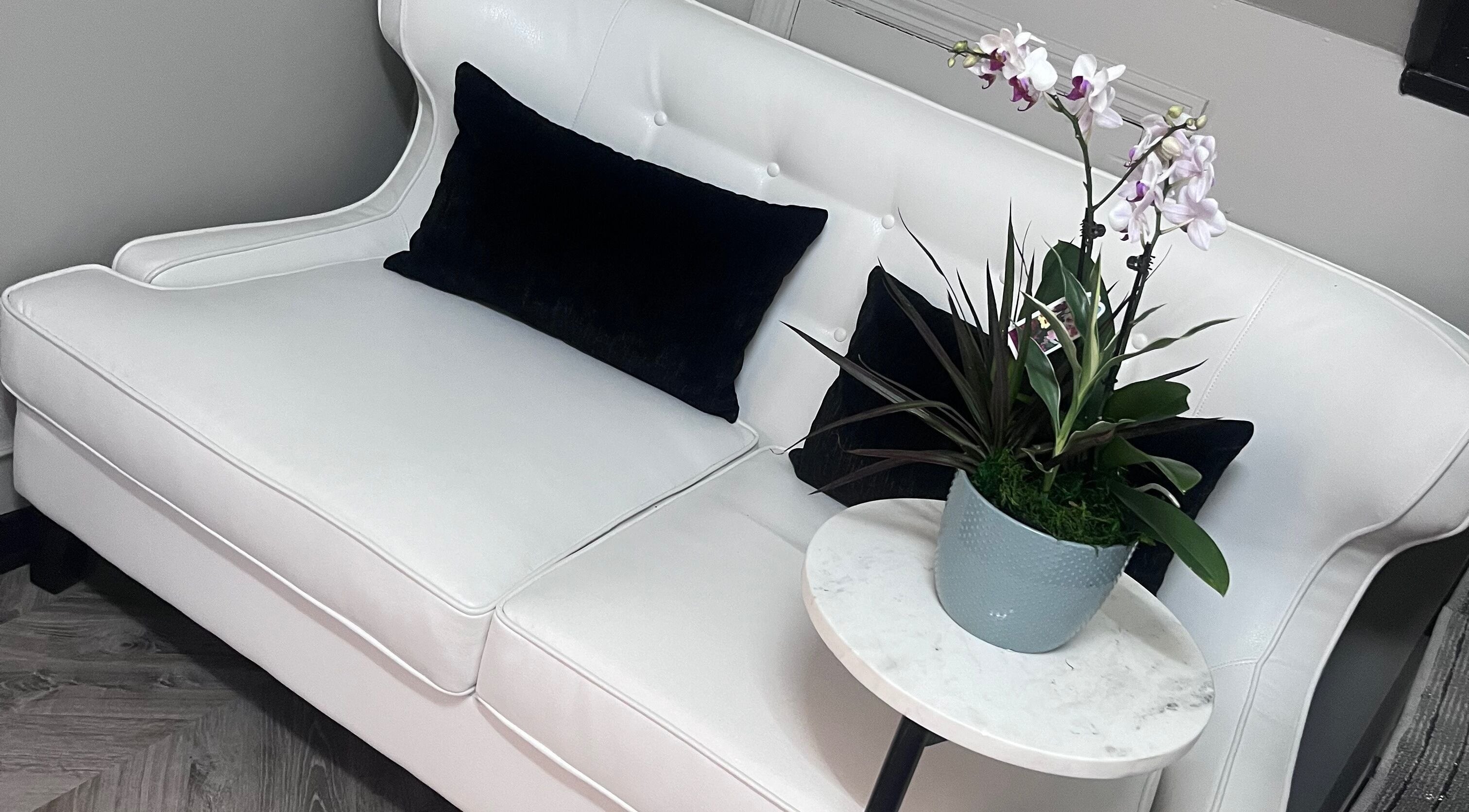 Elegant seating area with white couch at Luxe Aesthetics, Lexington, Kentucky, US.