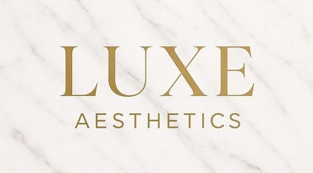 Luxe Aesthetics logo in gold on marble background, located in Lexington, Kentucky, US.