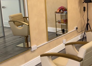 Modern salon interior at braidsbyashlee, Birmingham, England, GB featuring elegant chairs and mirrors.