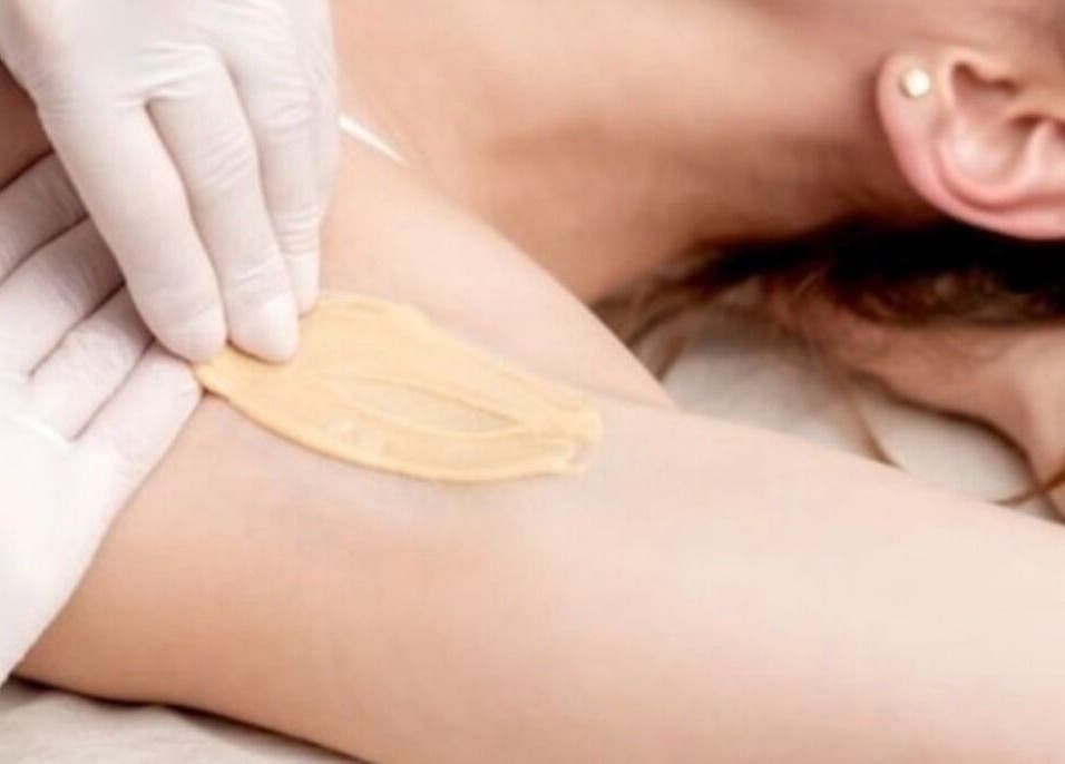 Depilación en Adriana Zullo MESOSKIN, Barcelona, Catalunya, ES. Manos aplicando cera suave en axila.