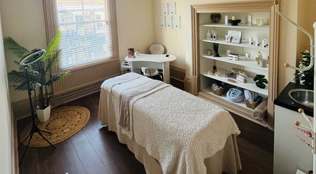 Serene massage room at Xela Massage and Skincare, Cottingham, England, GB with cozy decor and skincare products.