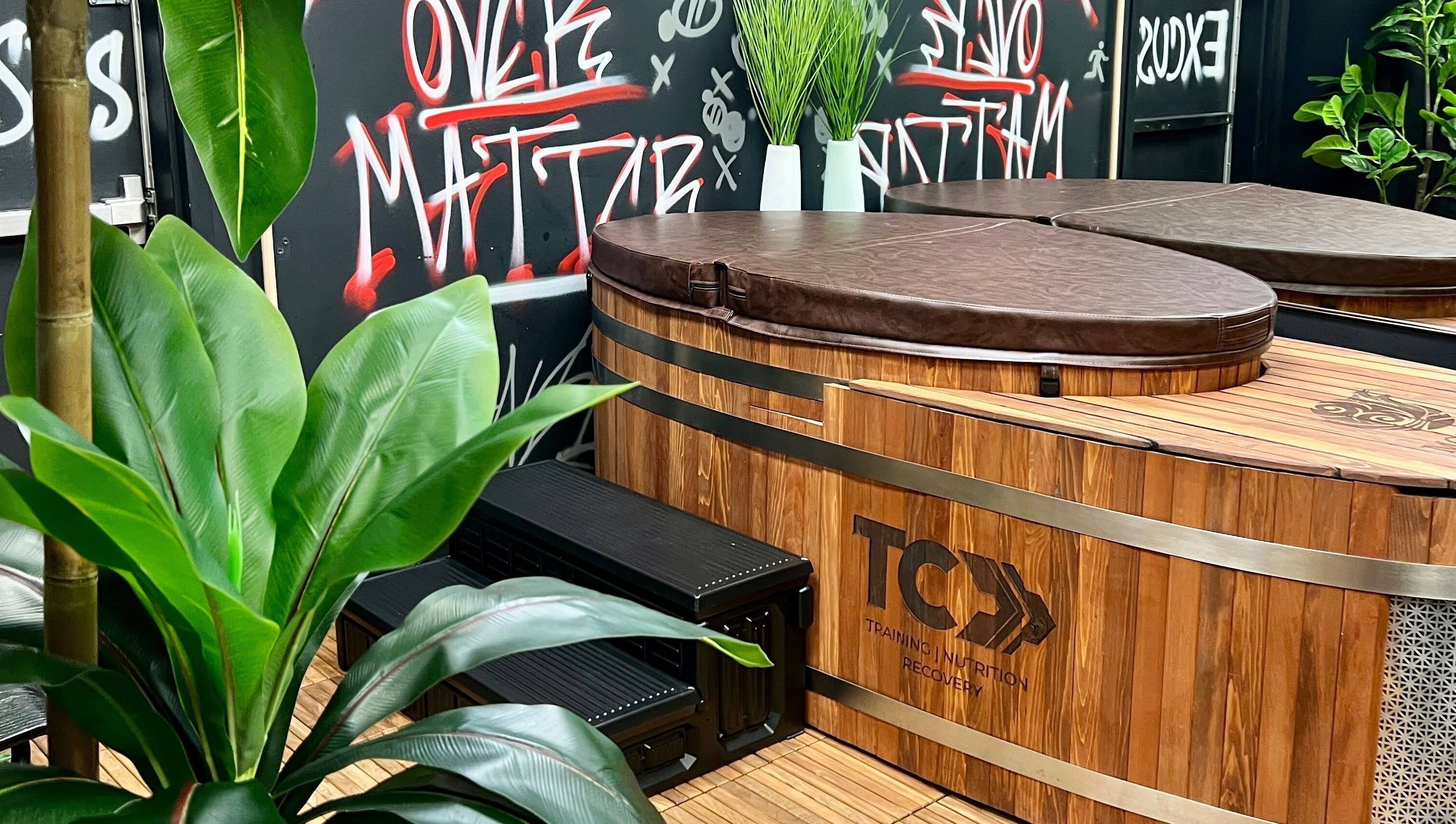 Luxurious wooden hot tub at Transformation Columbus, Powell, Ohio, US with vibrant plants and graffiti art.