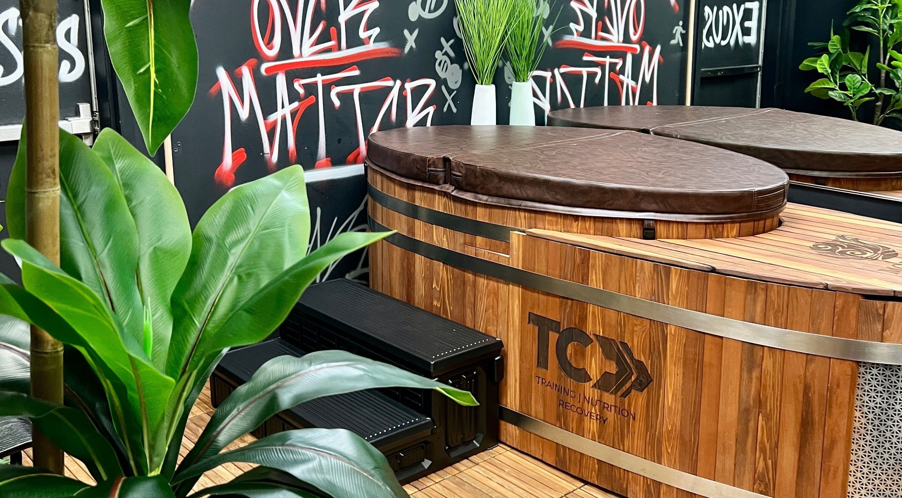 Luxurious wooden hot tub at Transformation Columbus, Powell, Ohio, US with vibrant plants and graffiti art.