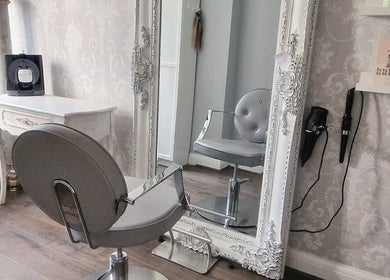 Elegant styling station at Scarlett Valentine Hair in Epsom, England, GB showcasing ornate mirror and chair.