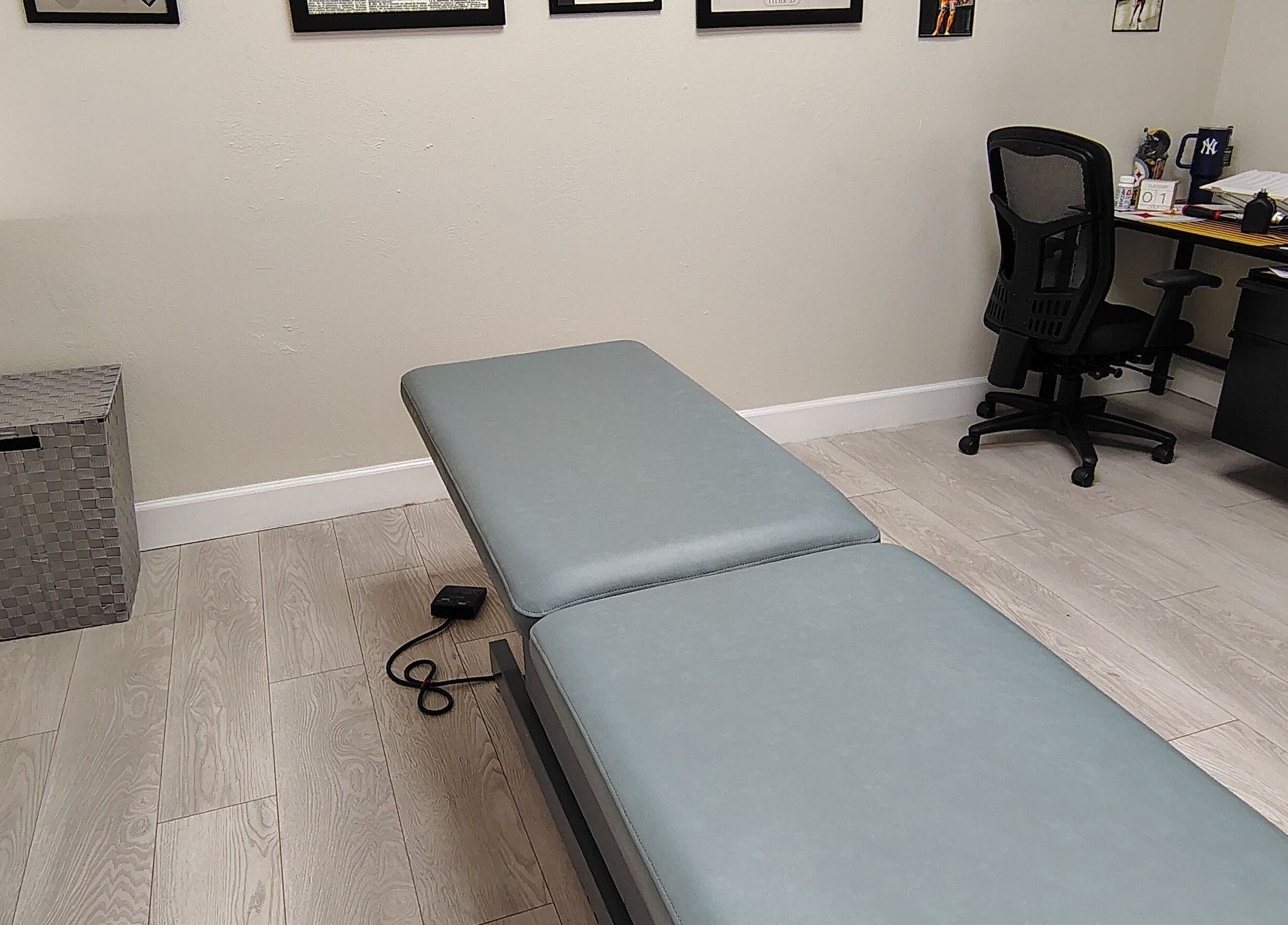 Professional massage room at Redefined Physique in Irving, Texas, US with treatment table and office setup.