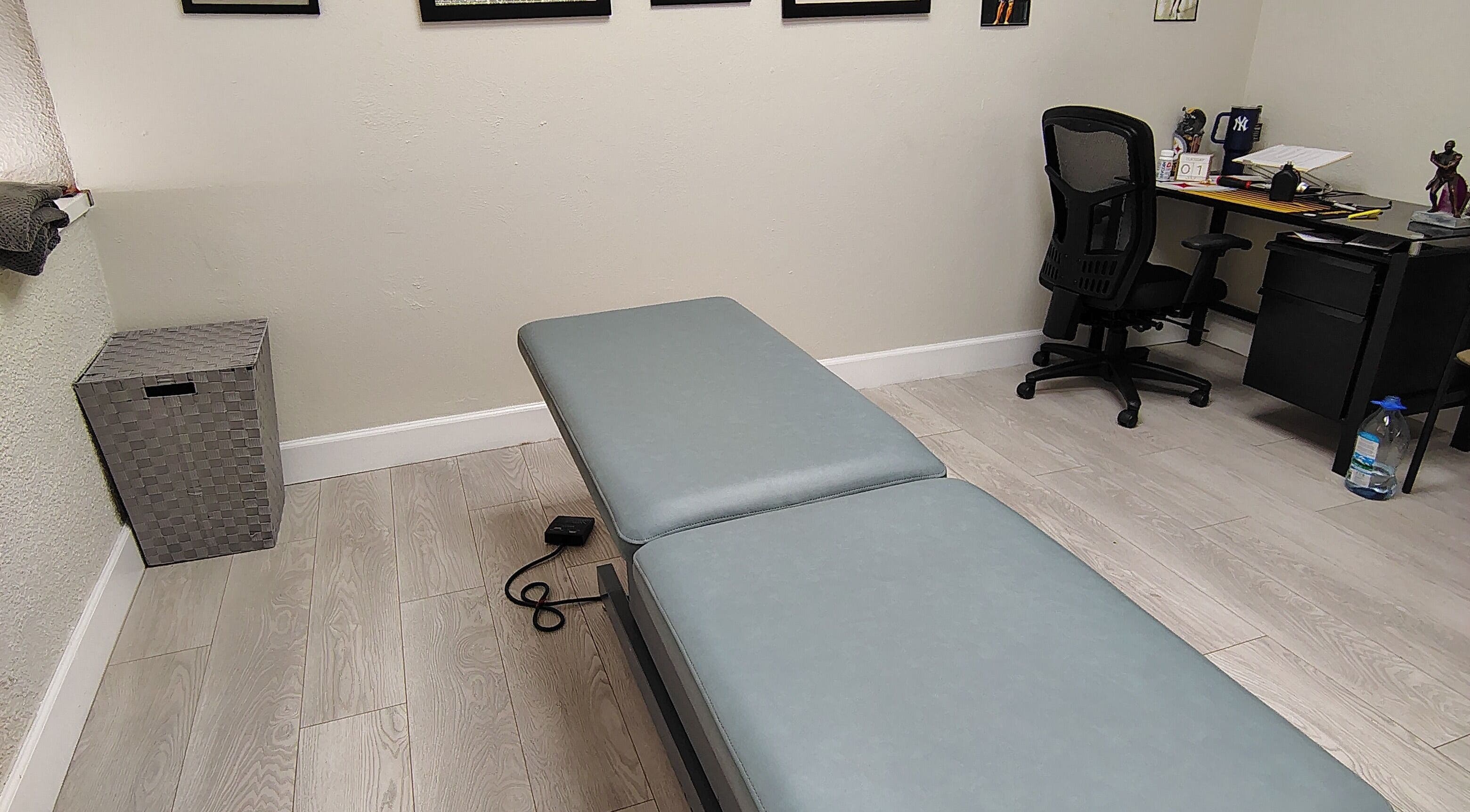 Professional massage room at Redefined Physique in Irving, Texas, US with treatment table and office setup.