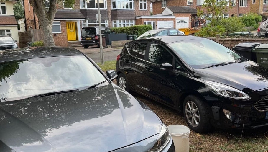 Driveway view at NJCleaningCo, St Albans, GB, showcasing parked cars and suburban homes.