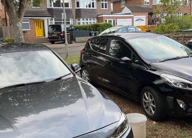 Driveway view at NJCleaningCo, St Albans, GB, showcasing parked cars and suburban homes.