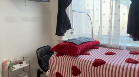 Cozy treatment room at Vibrae, London, England, GB with red accents and a striped blanket.