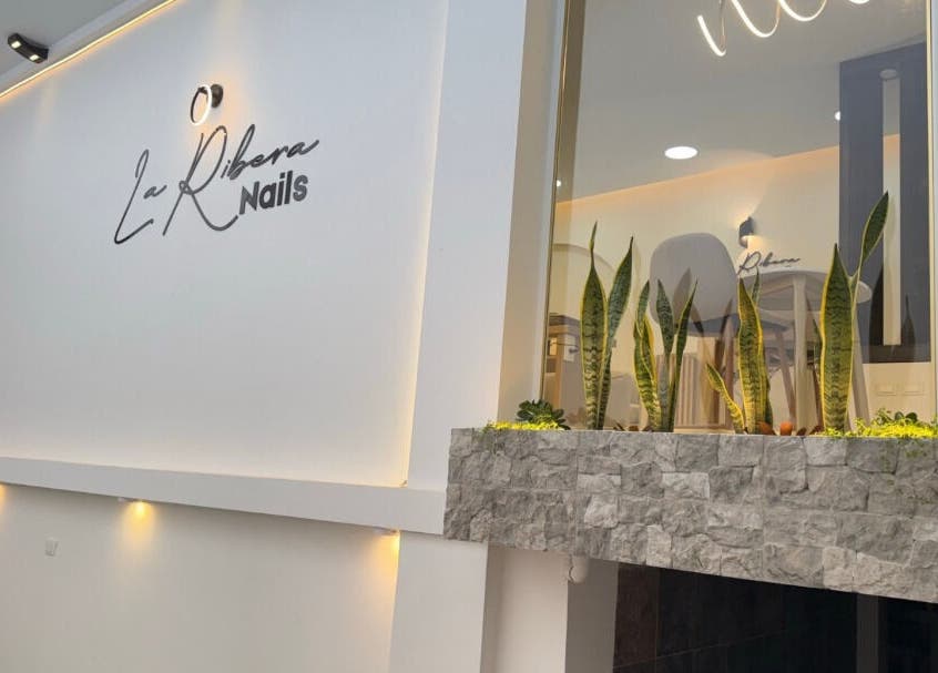 Entrada de La Ribera Nails ✨ en Babahoyo, Los Ríos, EC, con iluminación moderna y plantas decorativas.