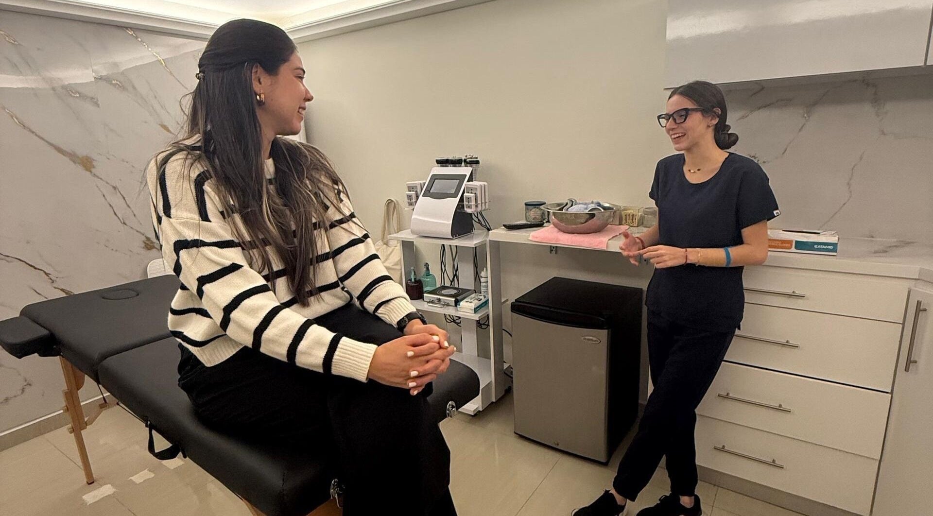 Cliente y esteticista conversando en Oasis Spa, Valencia, Carabobo, VE, mostrando un ambiente acogedor.