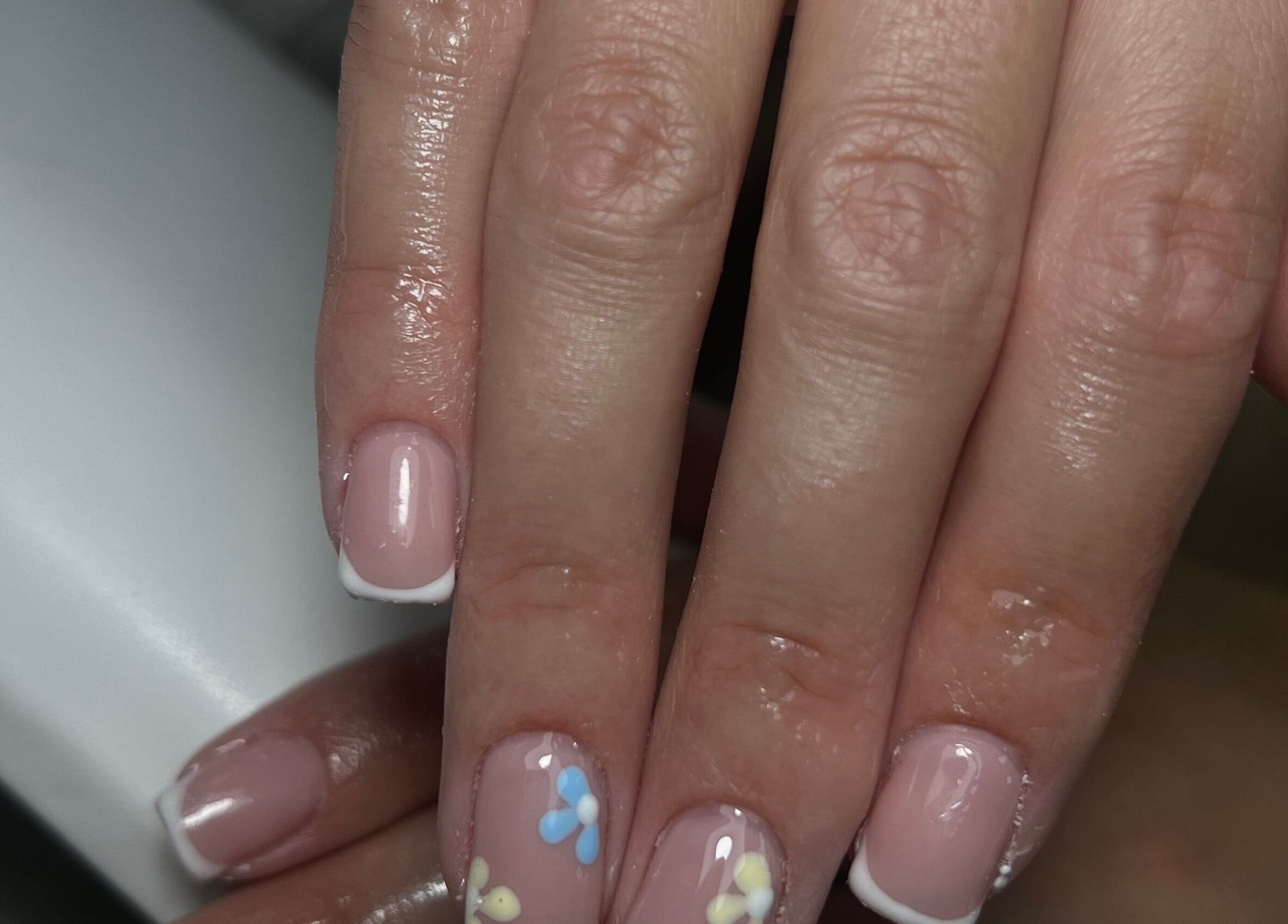 Elegant French manicure with floral designs at Nails by Cat, Cambuslang, Scotland, GB.