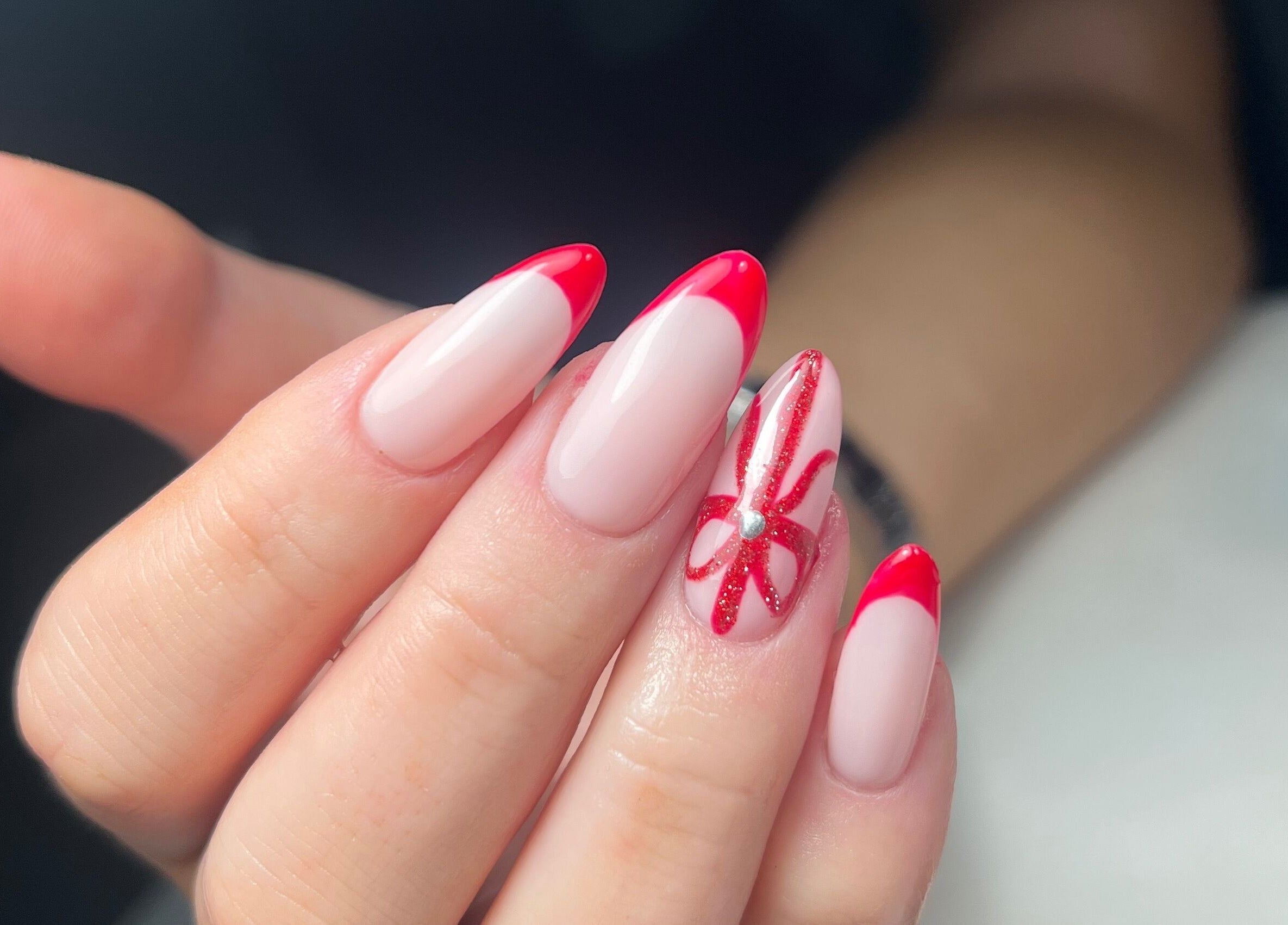 Elegant red-tipped nails with designs at Nails by Cat, Cambuslang, Scotland, GB.