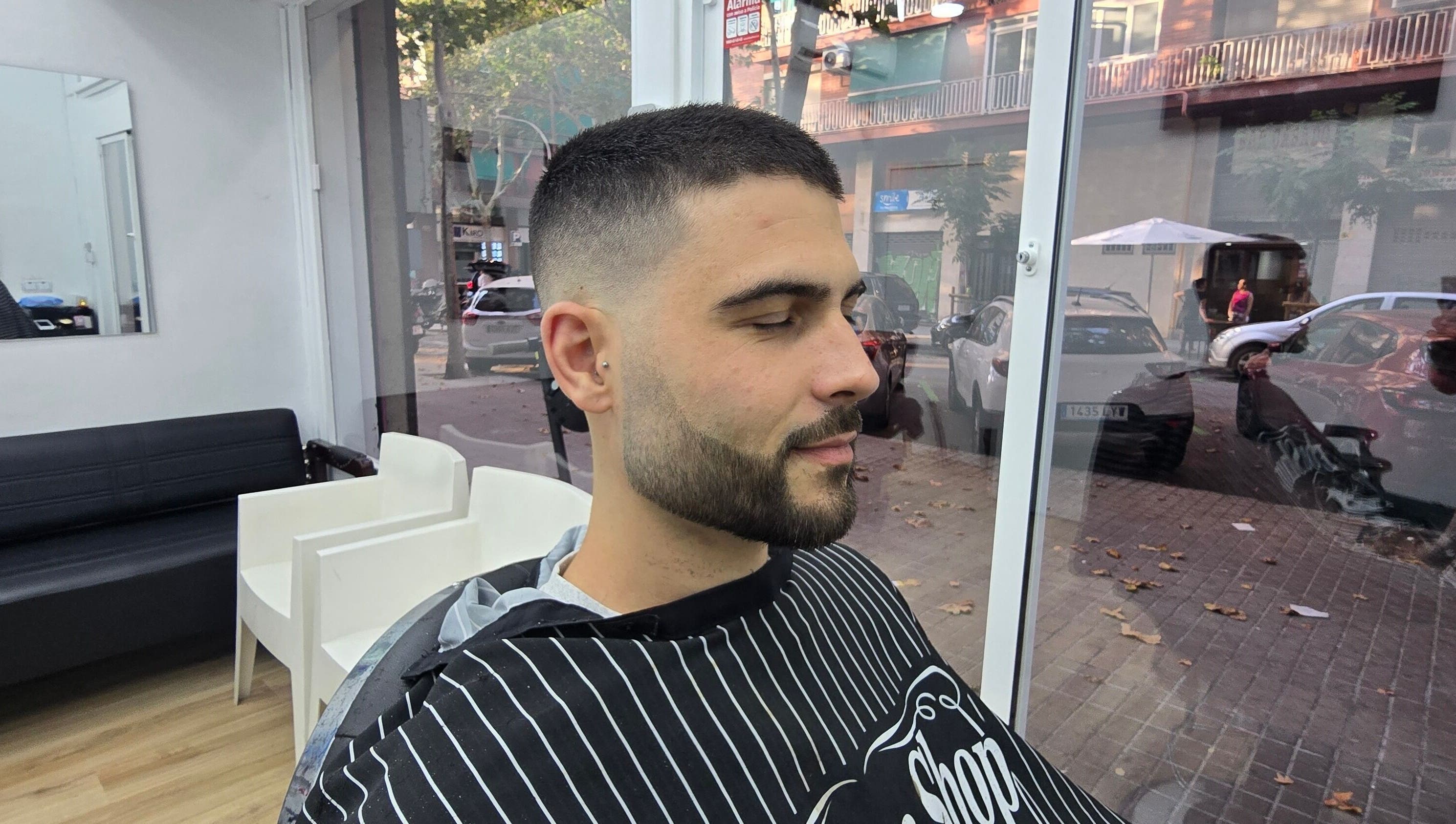 Hombre en Señor Barbero, Barcelona, Catalunya, ES, mostrando corte de pelo moderno y cuidado de barba.