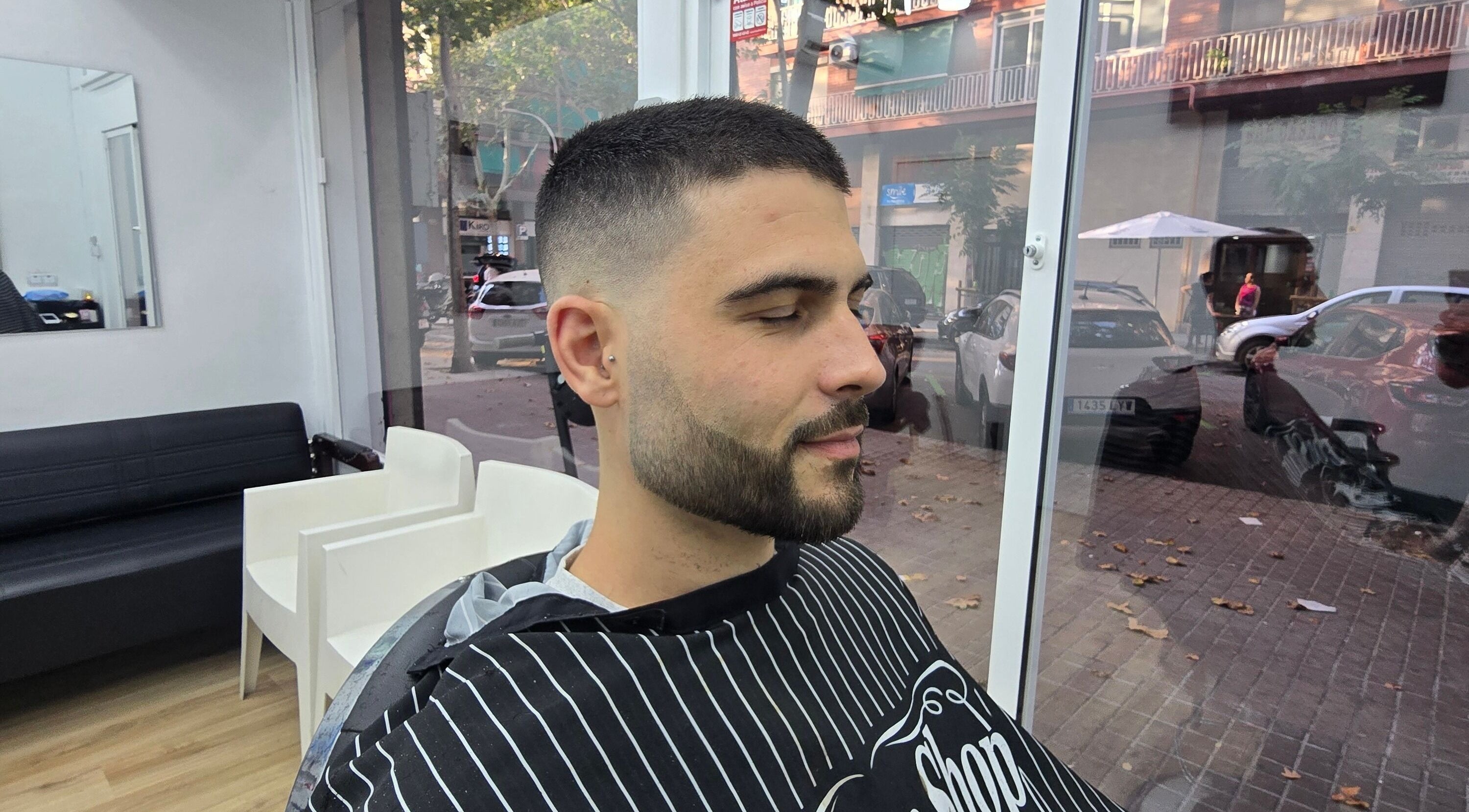 Hombre en Señor Barbero, Barcelona, Catalunya, ES, mostrando corte de pelo moderno y cuidado de barba.