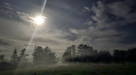Tranquil moonlit landscape at Wai Ora Spa Therapies, Pukenui, Northland Region, NZ, set against mist and trees.