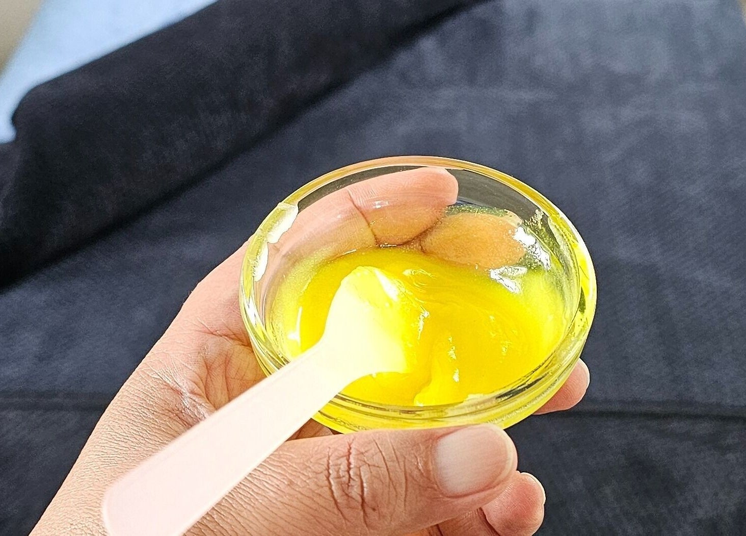 Hand holding a bowl of yellow balm at Wai Ora Spa Therapies, Pukenui, Northland Region, NZ.