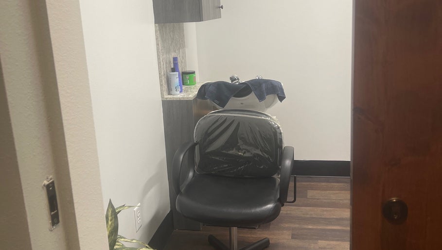 A stylish hair washing station at Thee Hair Slayer in Sandy Springs, Georgia, US, featuring a comfortable black chair.