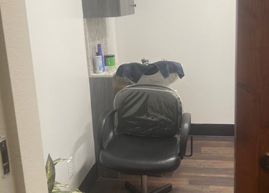 A stylish hair washing station at Thee Hair Slayer in Sandy Springs, Georgia, US, featuring a comfortable black chair.
