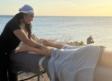 Terapia de masaje en Camila beauty spa, CW, con vista al mar al atardecer.