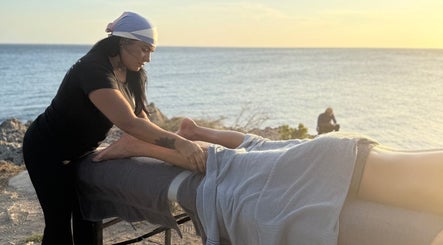 Terapia de masaje en Camila beauty spa, CW, con vista al mar al atardecer.