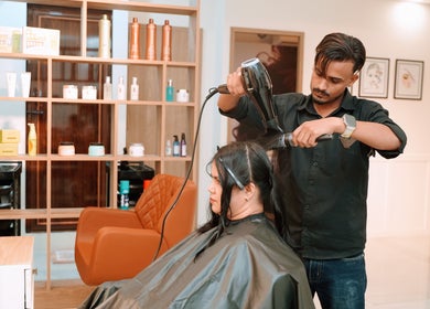 Stylist at Glam Studios Belathur Bengaluru giving a professional blowout.