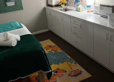 Sala de tratamiento en Welcome Spa, Alexandria, Virginia, US con cama de masaje decorada y muebles modernos.