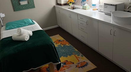Sala de tratamiento en Welcome Spa, Alexandria, Virginia, US con cama de masaje decorada y muebles modernos.