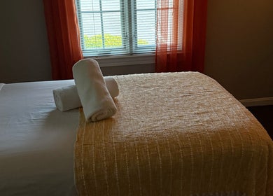 Relajante habitación de spa en Welcome Spa, Alexandria, Virginia, US, con toallas blancas sobre la cama.