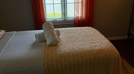 Relajante habitación de spa en Welcome Spa, Alexandria, Virginia, US, con toallas blancas sobre la cama.