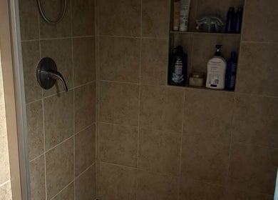Ducha elegante de Welcome Spa en Alexandria, Virginia, US, con azulejos beige y estantería integrada.