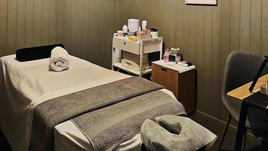 Elysian Beauty massage room in Winton, Southland Region, NZ. Cozy bed with essentials for relaxation.