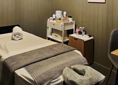 Elysian Beauty massage room in Winton, Southland Region, NZ. Cozy bed with essentials for relaxation.